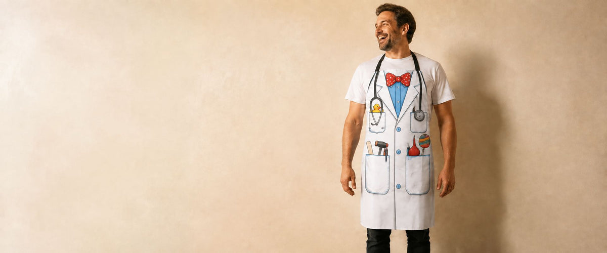 Homme riant en tablier blanc imprimé en trompe l'oeil d'une blouse de médecin, noeud papillon et stéthoscope dessinés.