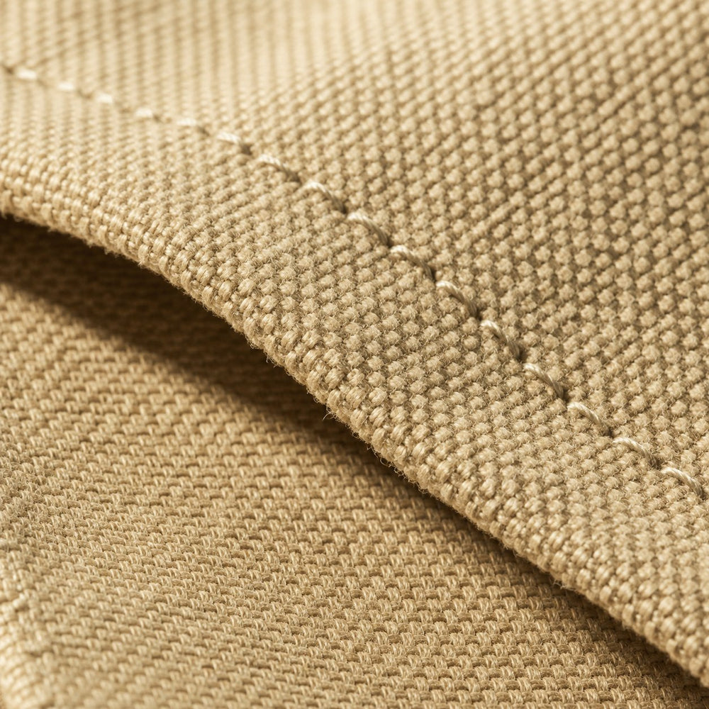Gros plan sur le tissu d'un tablier beige et sa couture