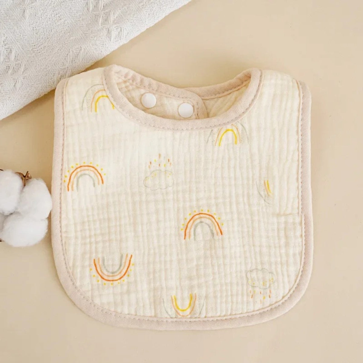 Bavette bébé en coton gaufré, motif imprimé sur fond écru, motif arc-en-ciel coloré, fond écru