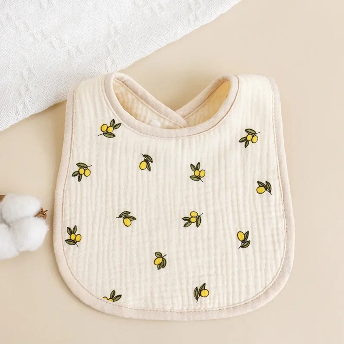 Bavette bébé en coton gaufré, motif imprimé sur fond écru, motif citrons, fond écru