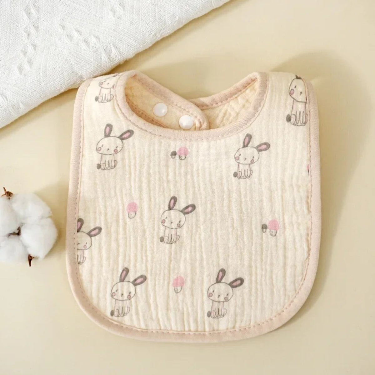Bavette bébé en coton gaufré, motif imprimé sur fond écru, motif lapins, fond écru