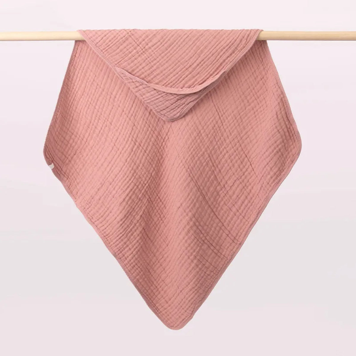 Tablier de bain bébé, la cape à capuche qu'on tend sur les bras, rose poudré, capuche dans un angle