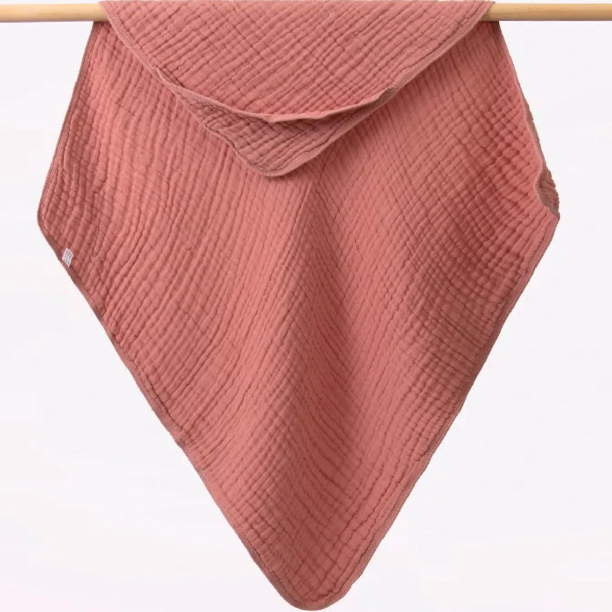 Tablier de bain bébé, la cape à capuche qu'on tend sur les bras, rose terracotta, capuche dans un angle